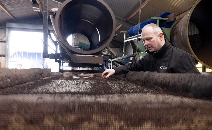 Living Green worker observing wormcast production Living Green worker observing wormcast production