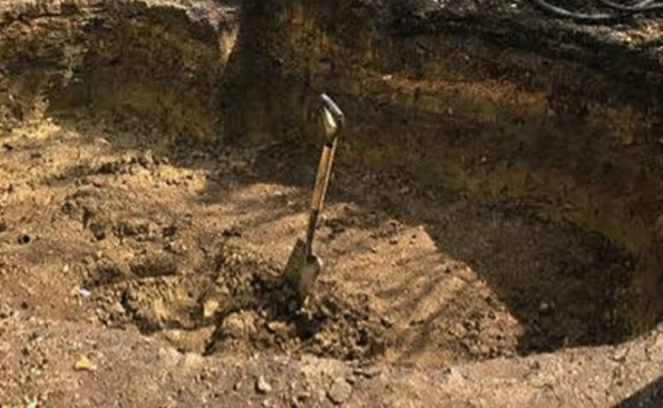 Shovel in area of excavated soil Shovel in area of excavated soil