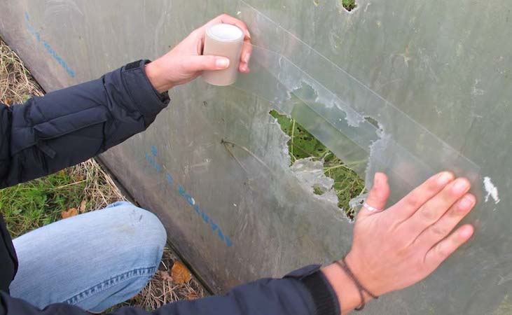repairing a polytunnel hole with tape