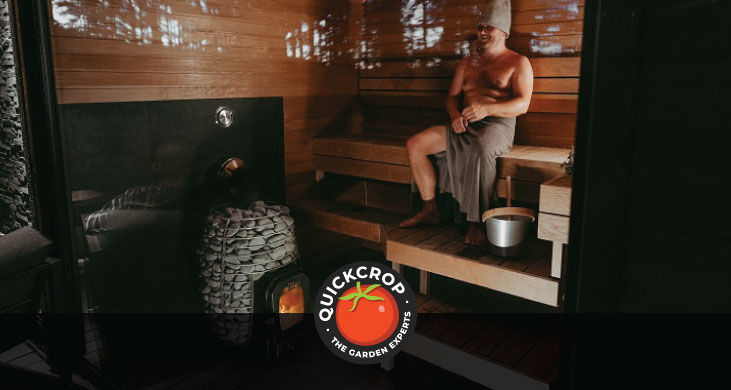 A very relaxed and happy person sitting on a sauna bench - header image