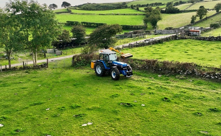 A tractor working on clearing hedgerow A tractor working on clearing hedgerow